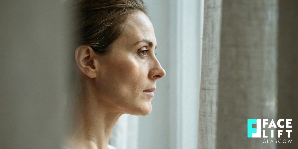 Serene side profile crop of a woman in her forties, focus on a firm jawline and neck in soft natural daylight, warm neutral tones, calm and aspirational
