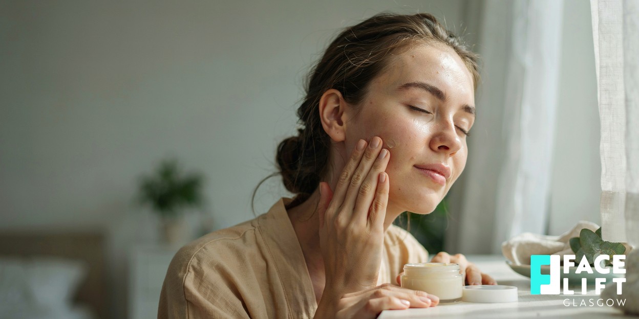 Woman applying a light facial moisturiser with SPF to her cheek and jaw in bright morning daylight, focus on healthy well-cared-for skin, fresh and calm